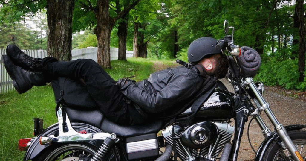Rider resting on motorcycle after fatigue during a long-distance bike ride