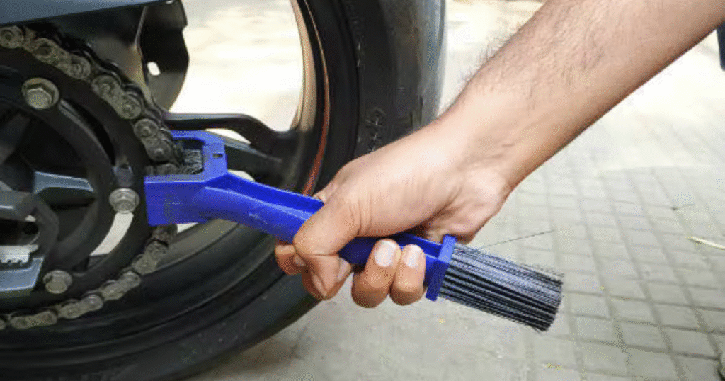 cleaning the motorcycle chain with brush to clean dirt and rust