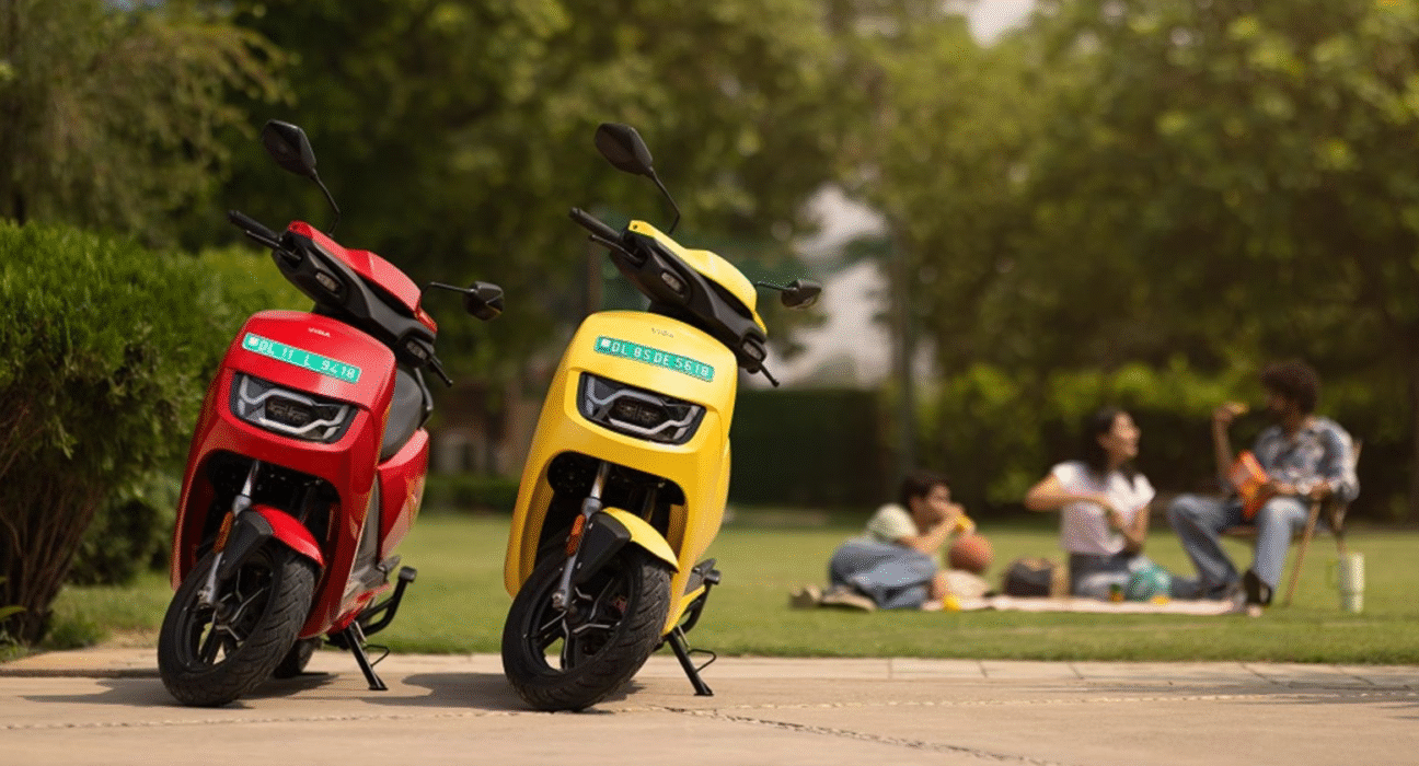 Hero Vida VX2 electric scooter parked on side stand in red and yellow color options