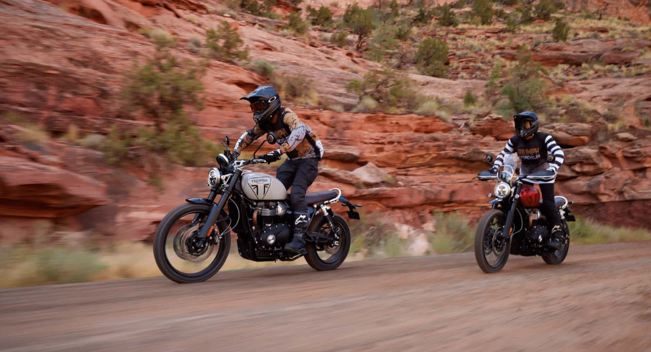 two riders are doing off road activity both are riding triumph scrambler 1200 x