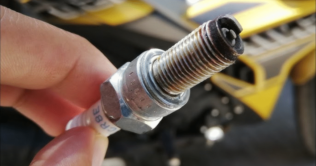 Worn-out motorcycle spark plug affecting engine performance