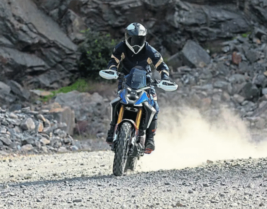 BMW F 450 GS adventure bike riding off-road, demonstrating suspension travel and rugged design