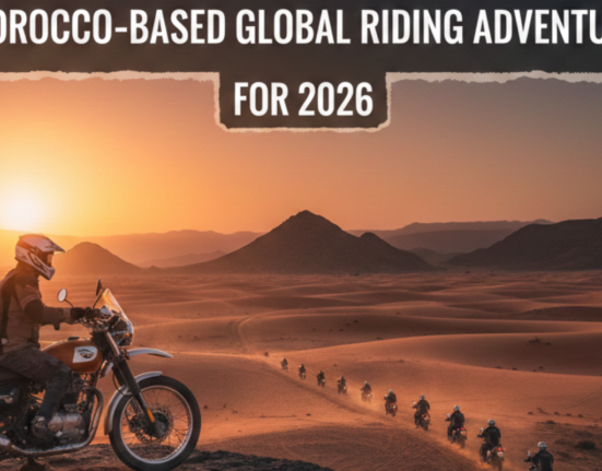 Royal Enfield motorcycle convoy riding through Sahara desert at sunset in Morocco